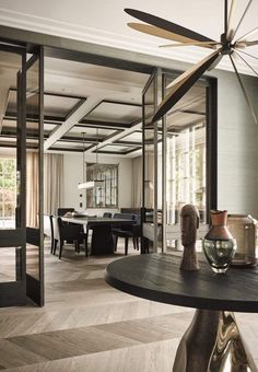 a living room filled with furniture and a ceiling fan in the middle of an open floor plan