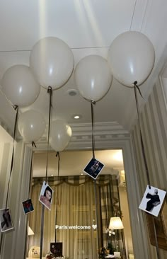 some white balloons hanging from the ceiling in a room