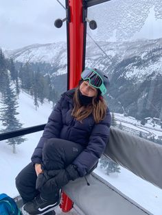 a woman sitting on top of a ski lift