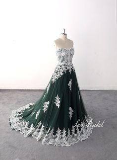 a green and white wedding dress with flowers on the bouncy skirt is displayed