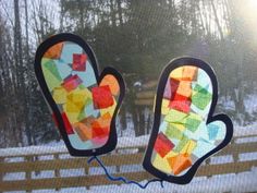 two mittens made out of gummy bears are hanging on a fence in the snow