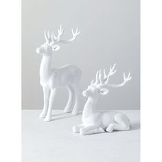 two white deer figurines sitting next to each other