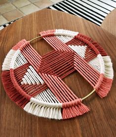 a wooden table topped with a red and white piece of art on top of it