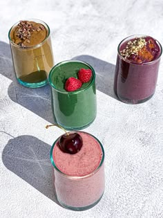 three glasses filled with different types of smoothies