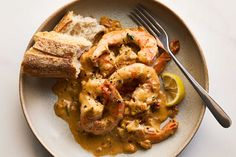 a white plate topped with shrimp, bread and gravy