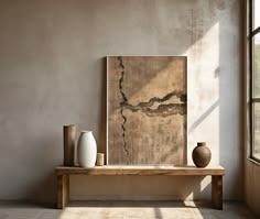 two vases are sitting on a wooden table in front of a large piece of art