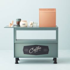 a small coffee cart with a laptop on top and other items sitting on the shelf