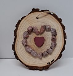 a piece of wood with a heart on it and some rocks in the shape of a heart