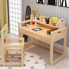 a child's wooden desk and chair set up in a room with pictures on the wall