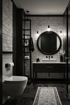 a black and white bathroom with a round mirror