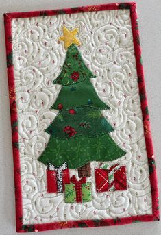 a quilted christmas tree with presents on it