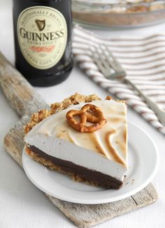 a piece of cake with pretzels on it and a bottle of guinness in the background