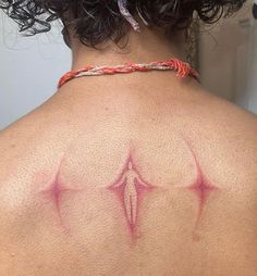 the back of a woman's shoulder with red ink on her upper arm and chest