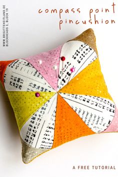 a decorative pillow made out of different colored fabrics and sequins with the words compass point pincustion on it