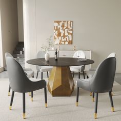 a dining room table with chairs around it and a vase on the table next to it