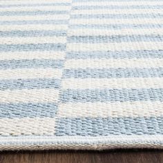 a blue and white rug on top of a wooden floor