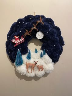 a christmas wreath hanging from the side of a wall with reindeer and snowman on it