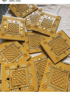 some yellow and white tiles on top of a sheet of paper with gold trimmings