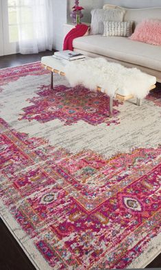 a living room area with a couch, coffee table and rug