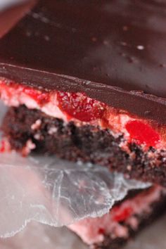 a close up of a piece of cake with chocolate and strawberries on it's side