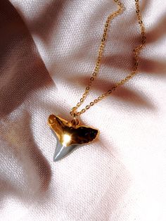 "Gold Shark Tooth Necklace | Gold Filled Necklace | Shark Tooth Pendant Necklace Necklace | Fossil Shark Tooth Necklace | Hawaii Shark Tooth | Hawaii Jewelry | Delicate Jewelry | Maui Mano niho kahi Black (mah NO-NEE ho-KA-hee) - Shark with one tooth. A gorgeous gold shark tooth pendant necklace. A single black shark tooth dipped in gold and strung on a gold filled chain. Lovely, striking, and unique. Perfect alone or as a lovely layered necklace. Handmade on Maui, Hawaii. ✦ DETAILS ✦ ✧ Model is Shark Tooth Necklace Gold, Ethereal Ocean, Shark Teeth Jewelry, Hawaii Necklace, Tooth Jewelry, Surf Necklace, Shark Tooth Pendant, Tooth Pendant, Hawaii Jewelry