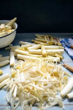 chopped up food sitting on top of a wooden table next to a bowl and knife