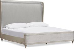 an upholstered bed with white sheets and pillows