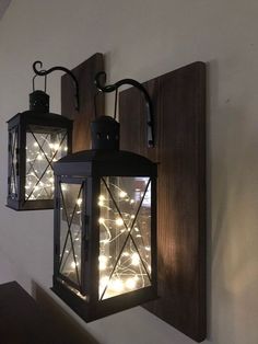 two lights are hanging on the wall next to each other in front of a light fixture