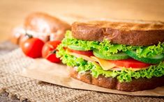 a sandwich with lettuce, tomatoes and cheese