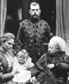 an old black and white photo of three people with a baby in front of them