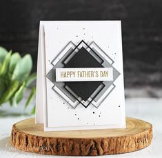 a father's day card sitting on top of a piece of wood next to a plant