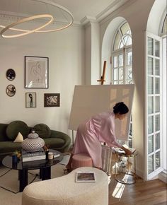 a woman is painting in her living room