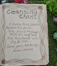 a book with writing on it sitting in the grass next to some potted plants