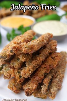 some fried food on a white plate with dipping sauces in the background and text that reads jalapeno fries deliciously seasoned