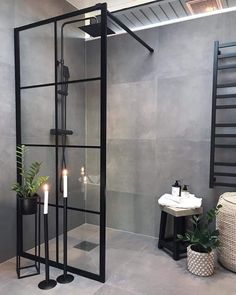 a bathroom with a glass shower door and candles