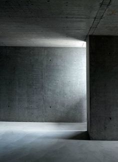 an empty room with concrete walls and floor