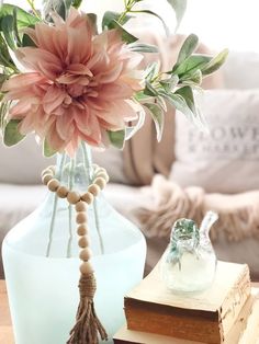 a vase filled with pink flowers sitting on top of a table next to a book