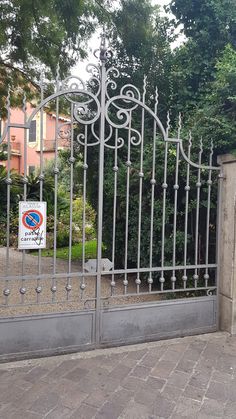 an iron gate with a sign on it