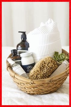 a basket filled with personal care items on top of a white bed sheet next to a red frame