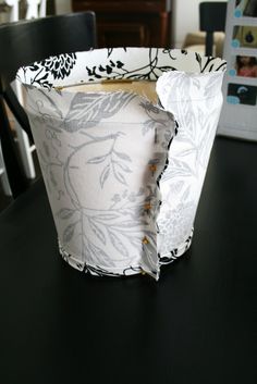 a paper cup sitting on top of a table next to a black and white chair