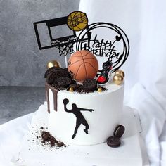 a birthday cake decorated with basketballs, cookies and other sports related items is shown