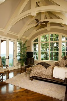 a bedroom with a ceiling fan and large windows