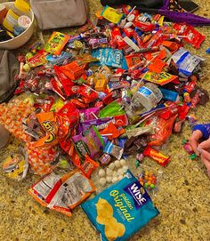 a pile of candy on the floor next to a purse