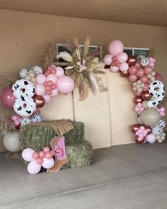 a bunch of balloons that are on top of some hay bales and other items