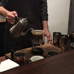 a person pours coffee into cups on a table