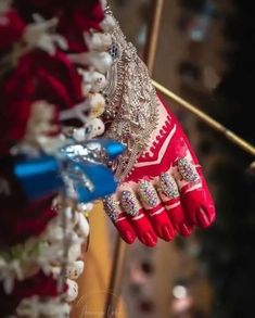 a close up of a person's hand wearing red and white gloves with jewels on it