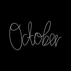 the word october written in cursive writing on a black background with white ink