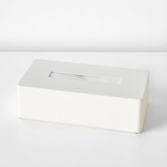 a white tissue dispenser sitting on top of a table