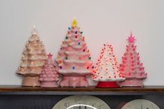 there are three christmas trees on top of the mantle and one is pink, white, and gold