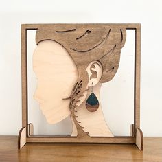 a wooden cutout of a woman's face with earrings